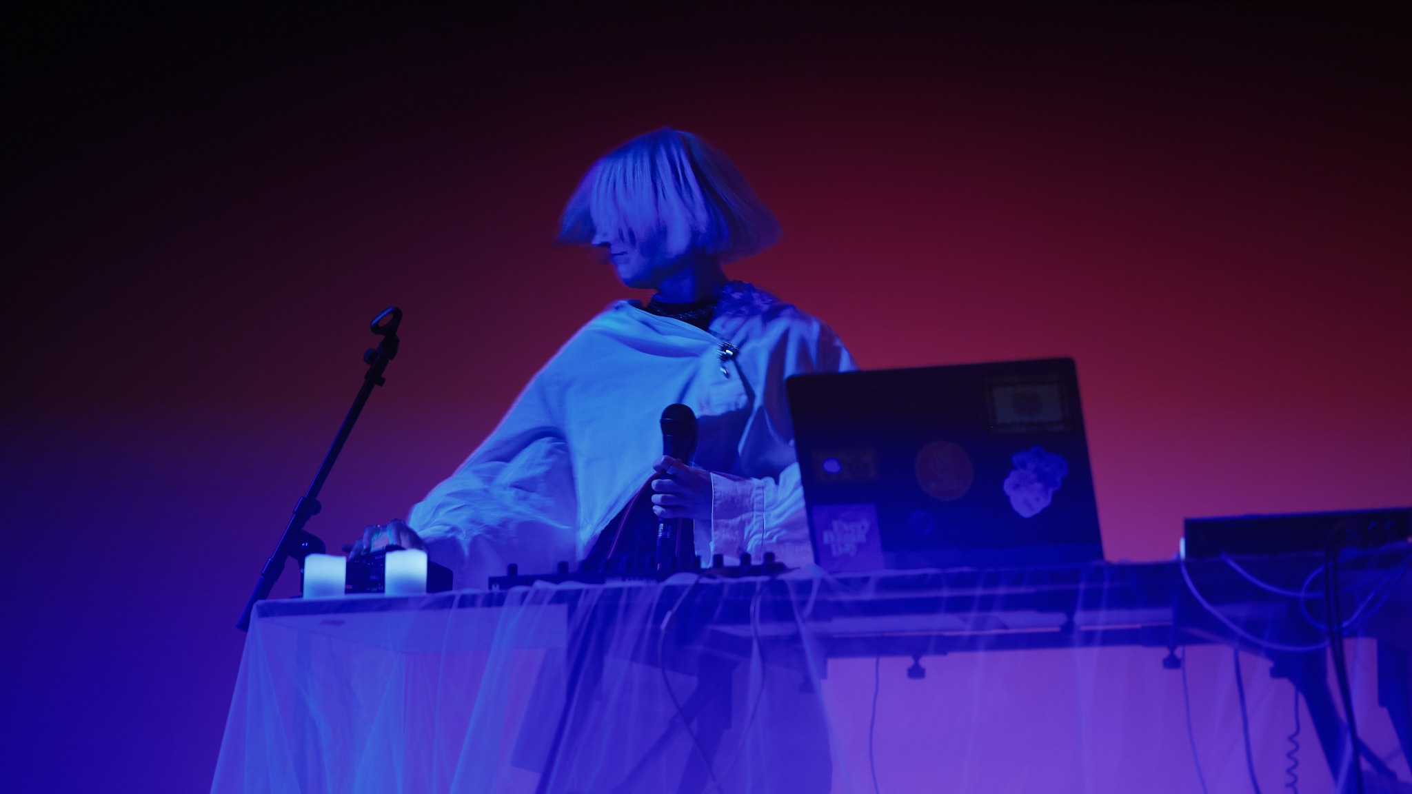 Jekka performing Delicate Chaos live in blue and magenta light