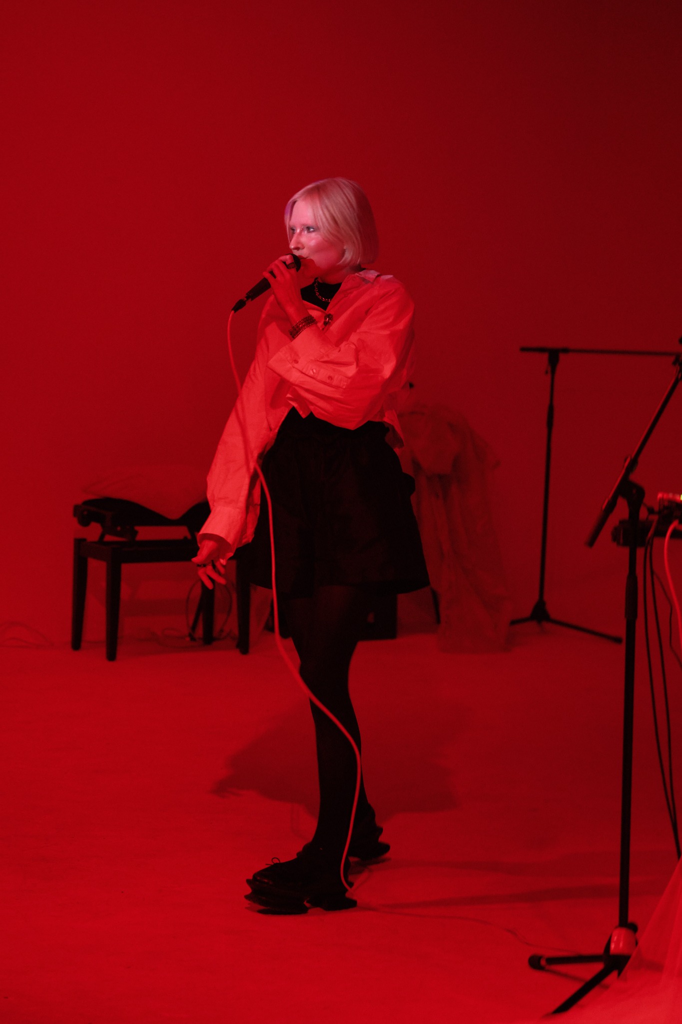 Jekka performing Delicate Chaos live against a red backdrop